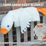 White 3 in 1 farm goose crochet baby blanket folded into a plush goose, with an orange beak and feet, displayed over a wooden bench. Original design by Ariana of CraftingHappiness.