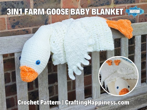 White 3 in 1 farm goose crochet baby blanket folded into a plush goose, with an orange beak and feet, displayed over a wooden bench. Original design by Ariana of CraftingHappiness.