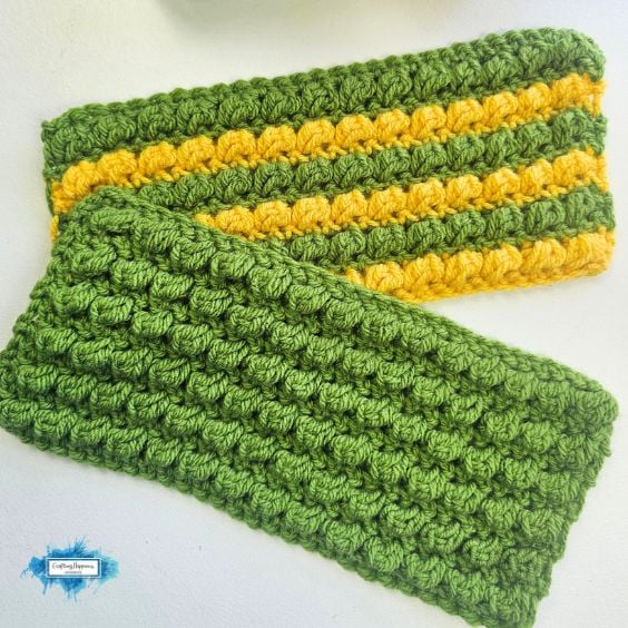 Two crocheted headbands with a textured bobble stitch; one is solid green and the other has green and yellow stripes