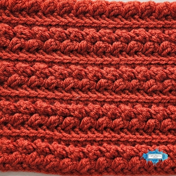 Braided Leaves Stitch Crochet Tutorial And Video - Crafting Happiness.jpg A close-up orange crochet swatch shows the Braided Leaves Stitch worked in repeating textured rows with raised braided leaf details. The Braided Leaves Stitch was created by Ariana Wimsett, a known crocheter and author, and the crochet work shown here was also made by her.